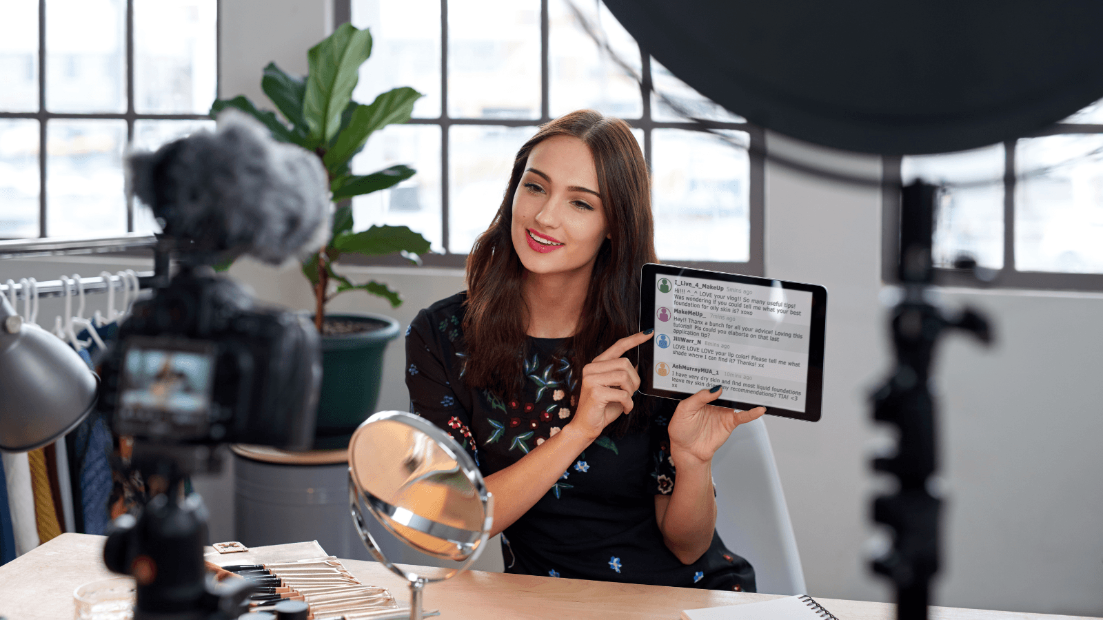 Creatrice di contenuti registra un video e mostra i commenti dei follower su un tablet